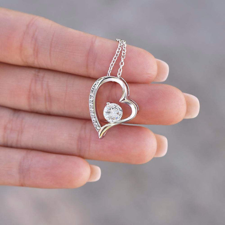 white gold forever love necklace in a model's hand