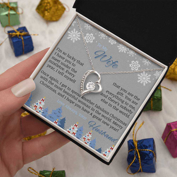 white gold forever love necklace in soft box in a model's hand