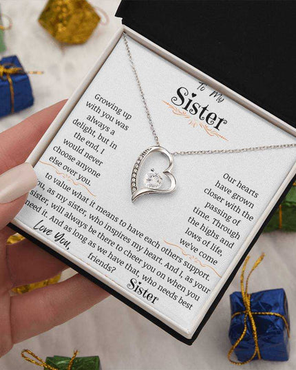 a white gold forever love necklace in a hand angled right
