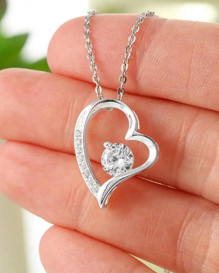 white gold forever love necklace in a model's hand