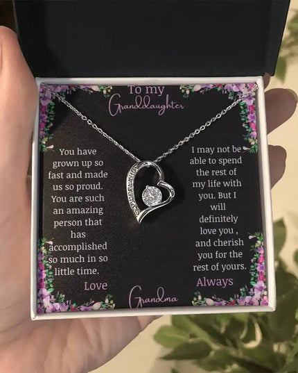 Forever Love Necklace with a white gold charm on a for granddaughter from grandpa greeting card in a two-tone box in a models hand
