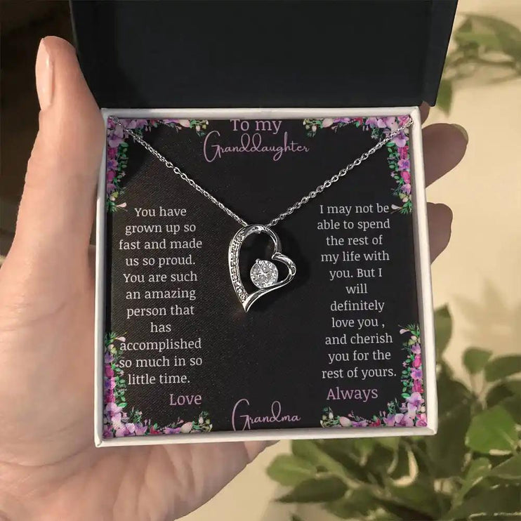 Forever Love Necklace with a white gold charm on a for granddaughter from grandpa greeting card in a two-tone box in a models hand