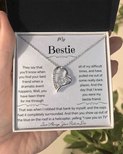 a white gold forever love necklace up close in a models hand