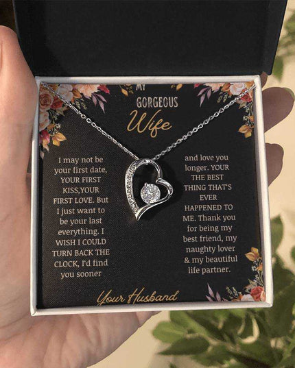 A white gold Forever Love Necklace on a to wife greeting card in a models hands.
