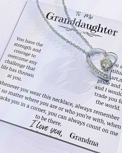 a white gold forever love necklace up close with pendant slid to the side.