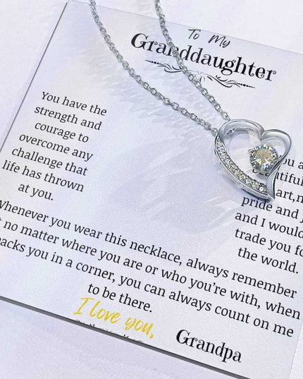 a white gold forever love necklace up close with charm slid to side