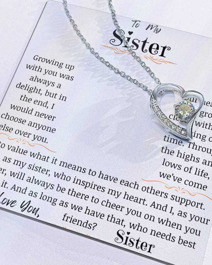 a white gold forever love necklace with charm slid to the side