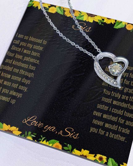 Forever Love Necklace with a white gold charm on a To Sis from Sis greeting card up close with charm slid to the side