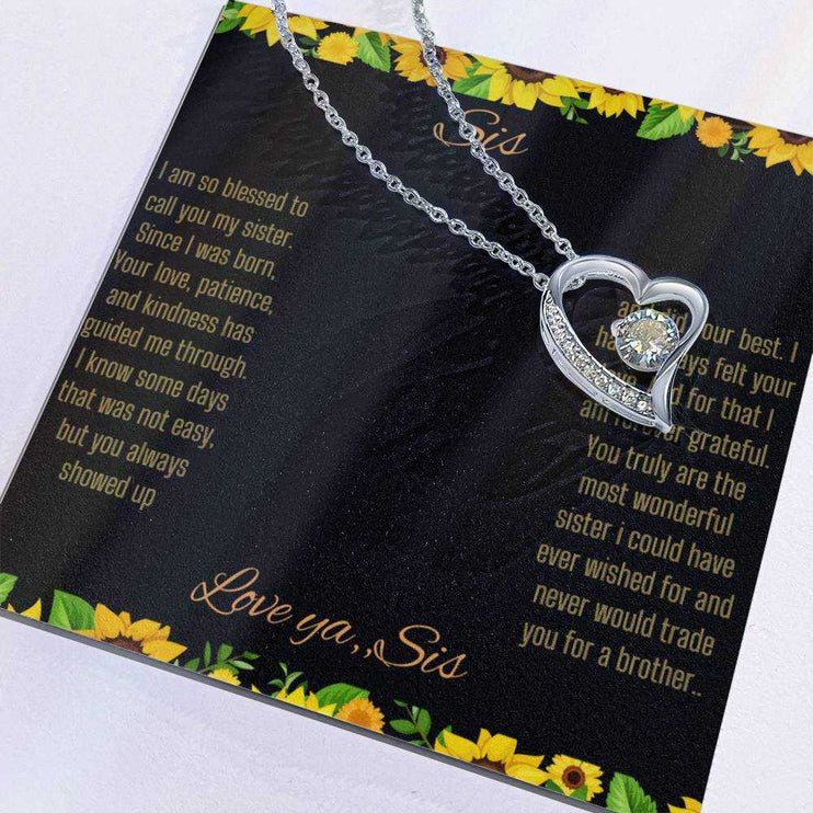 Forever Love Necklace with a white gold charm on a To Sis from Sis greeting card up close with charm slid to the side
