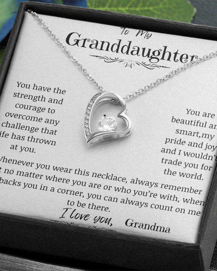 a white gold forever love necklace up close in a two-tone box.