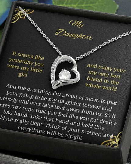Forever Love Necklace with a white gold pendant in a two-tone box with a to daughter from mom greeting card angled away to the left with leaves around box