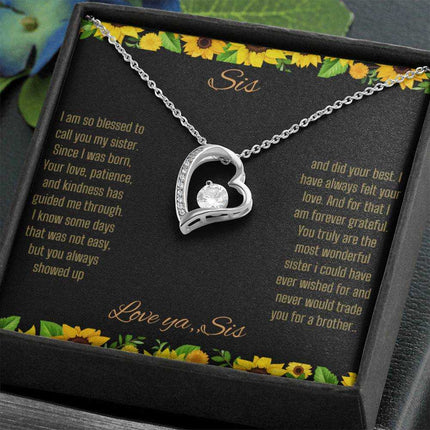 Forever Love Necklace with a white gold charm on a To Sis from Sis greeting card close up in a two-tone box angled to the right