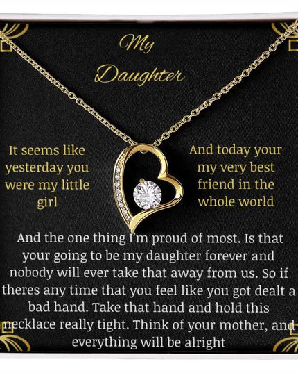 Forever Love Necklace with a yellow gold charm in a two-tone box with a to daughter from mom greeting card close up looking straight down
