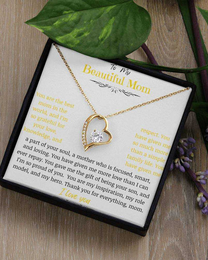 A yellow gold forever love necklace on a table