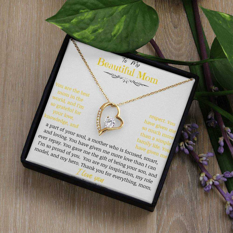 A yellow gold forever love necklace on a table