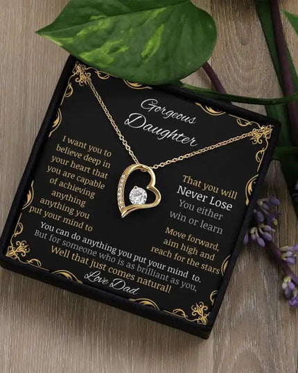 Forever Love Necklace with a yellow gold pendant in a two-tone box with a to daughter from dad greeting card angle further away on table angled left