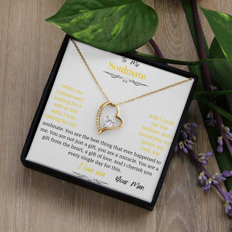 A yellow gold forever love necklace up close in a two-tone box