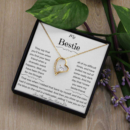 a yellow gold forever love necklace on a table