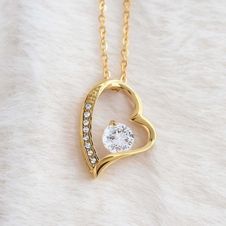 yellow gold forever love necklace on a white plush cloth 