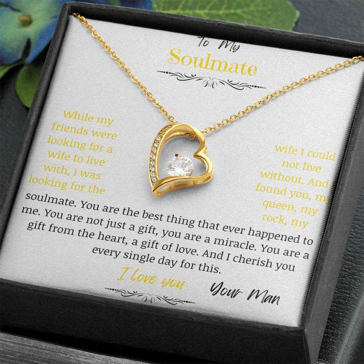 A yellow gold forever love necklace up close in a two-tone box angled to the right