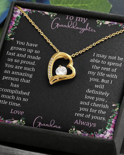 Forever Love Necklace with a yellow gold charm on a for granddaughter from grandpa greeting card in a two-tone box on a table angled left with a close up